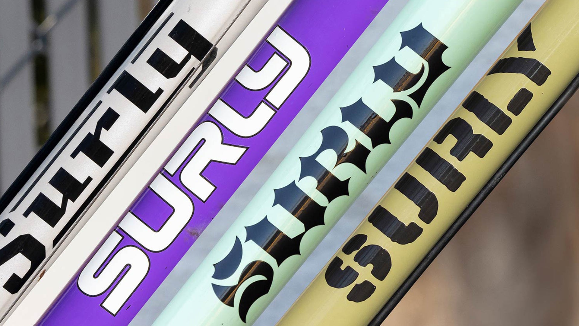 Collage image of different Surly decals on different color bike down tubes