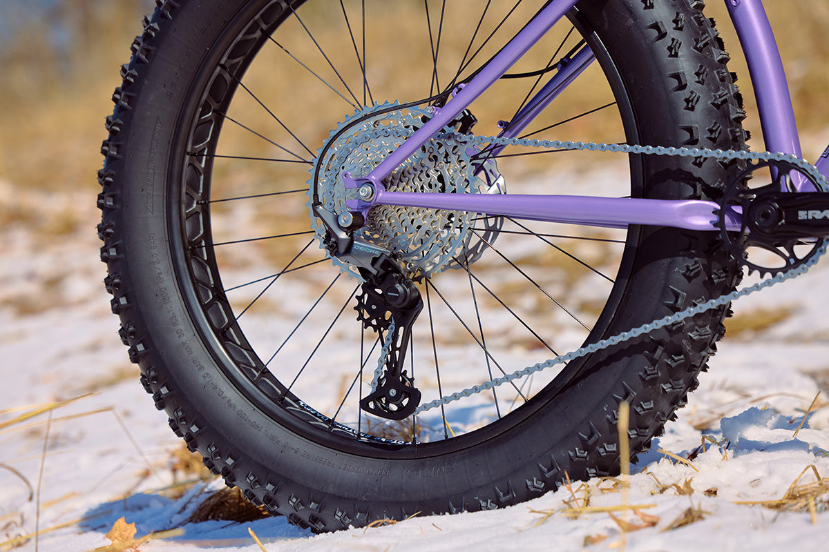 Surly Ice Cream Truck purple color focus on rear wheel and drivetrain on snow