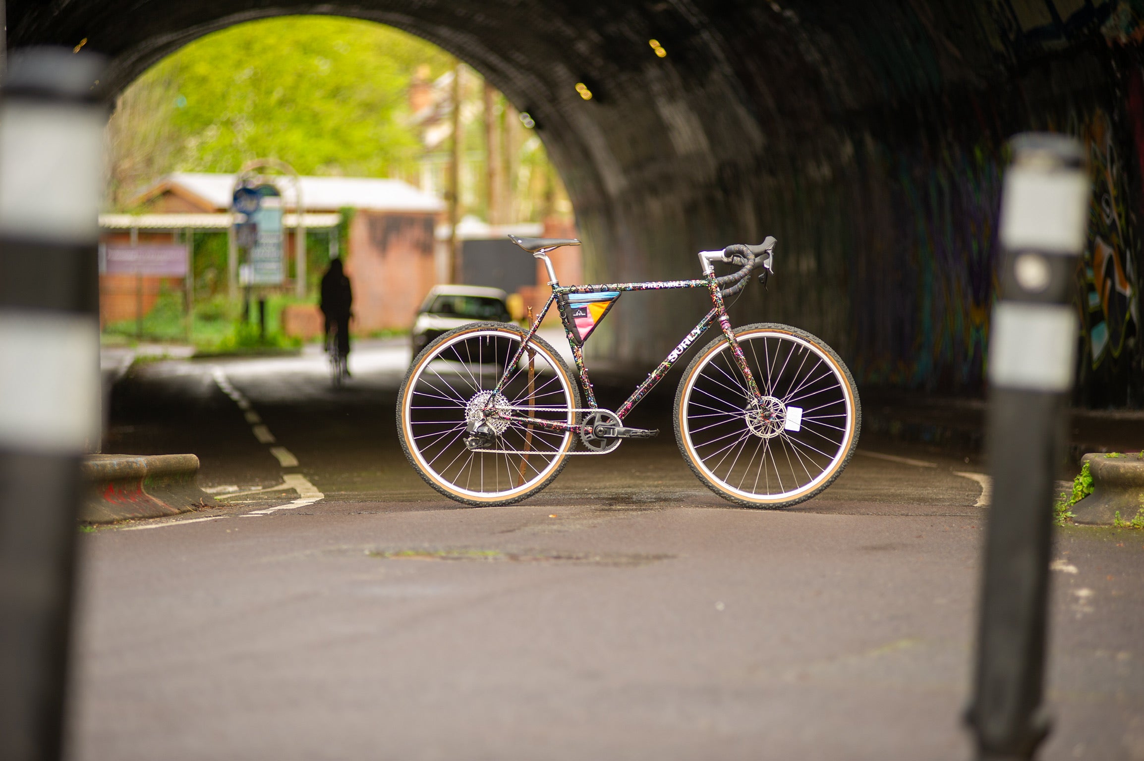 Custom Surly Preamble held up by stick in middle of road in front of tunnel