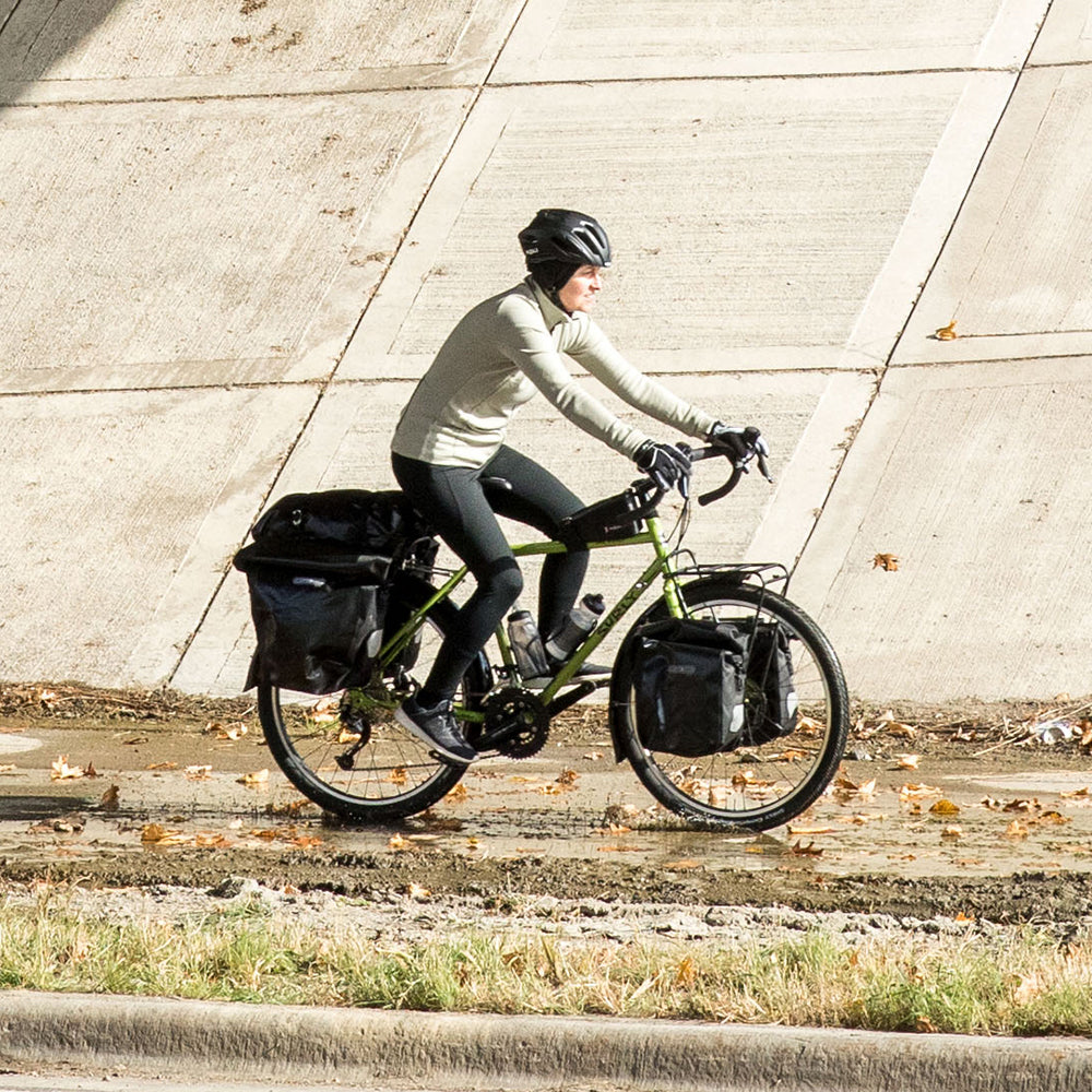 Person riding Surly Disc Trucker loaded with pannier bags