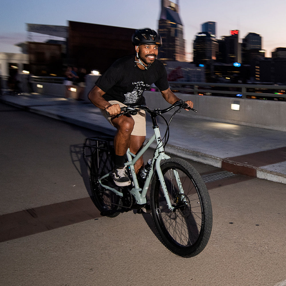 Person riding Surly Skid Loader on bridge at dusk