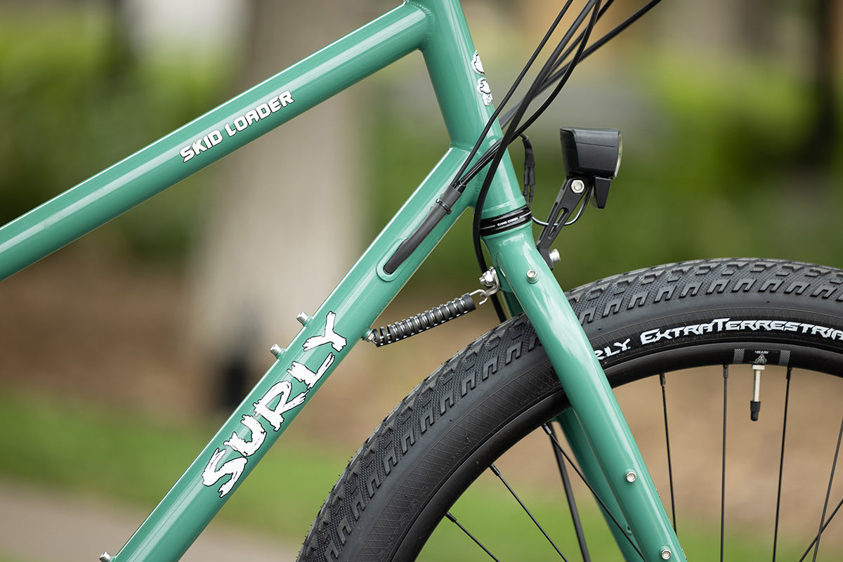 Front-end side view showing frame graphics and Surly decals on Skid Loader cargo e-bike
