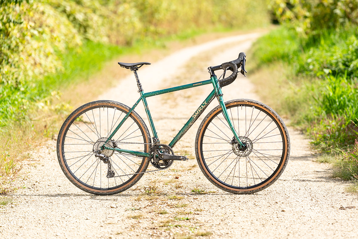 Surly Straggler bike in Subtropic Algae color side view on gravel road in sun