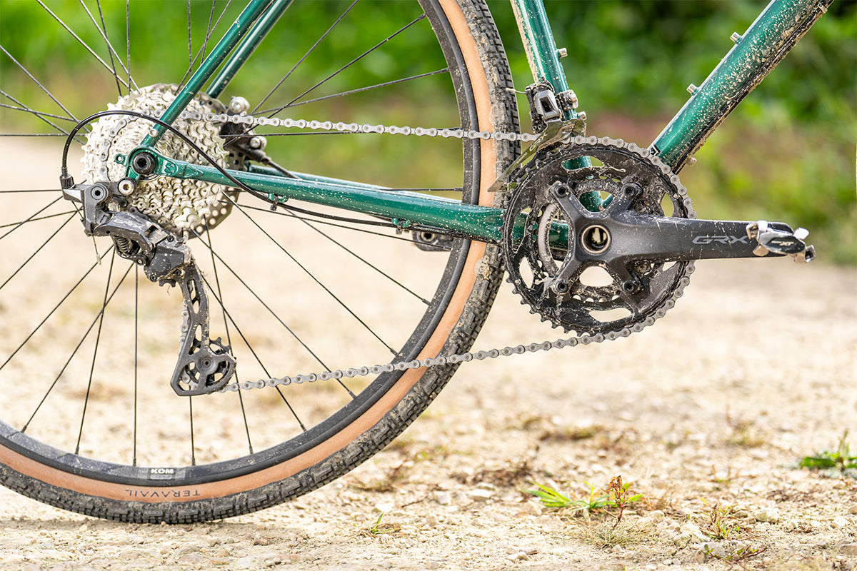 Surly Straggler bike in Subtropic Algae color side view drivetrain focus on gravel road