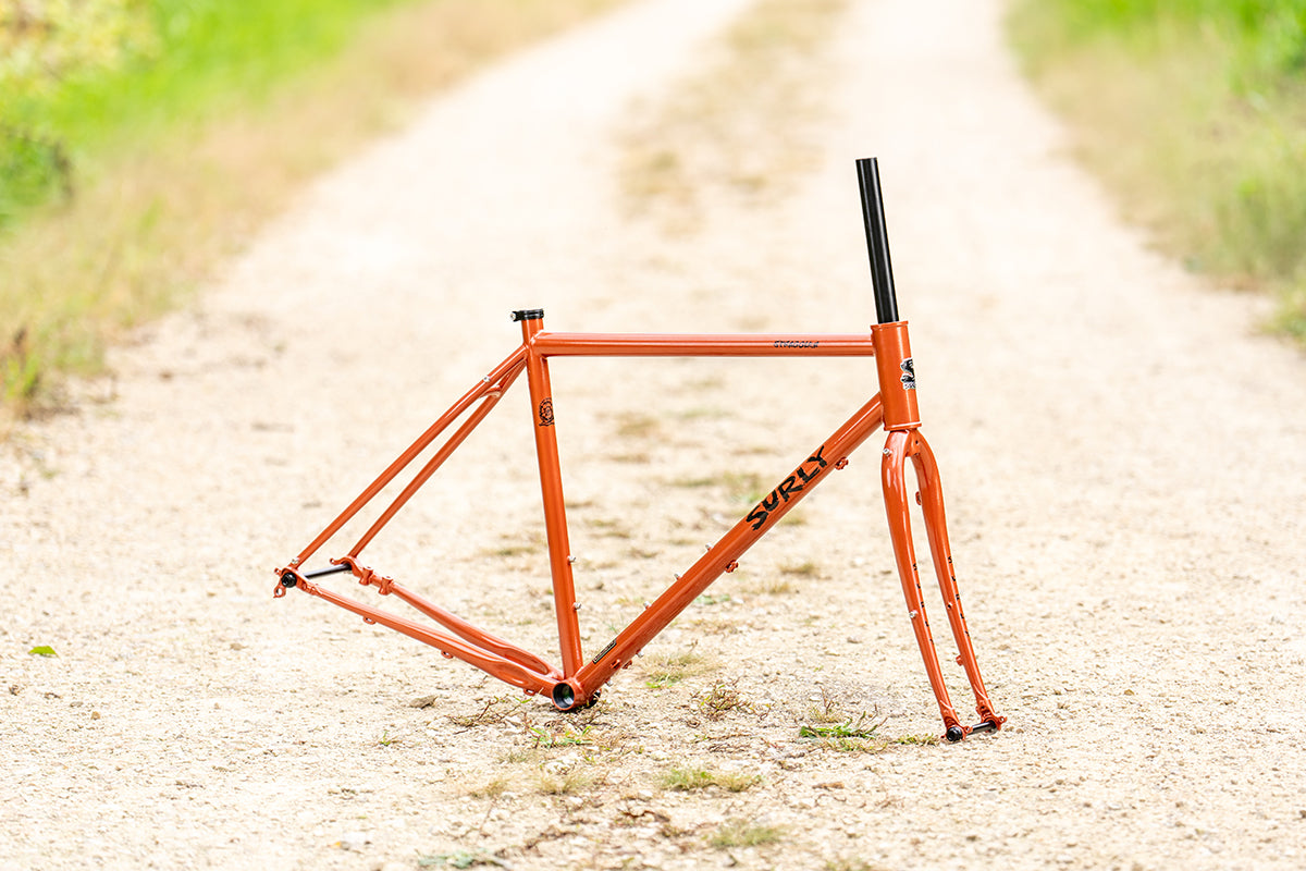 Surly Straggler Frameset in Shaggy Carpet orange color side view on gravel road