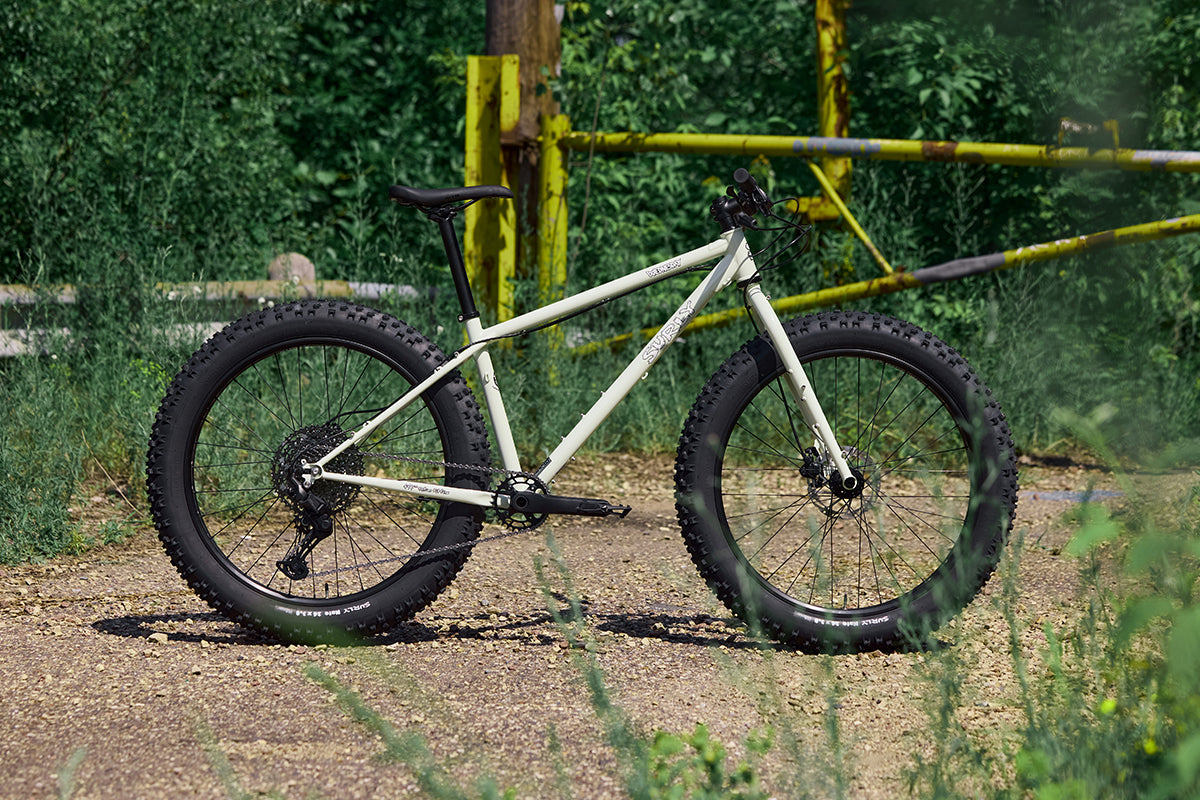 Surly Wednesday fat bike on a dirt path with greenery in the background