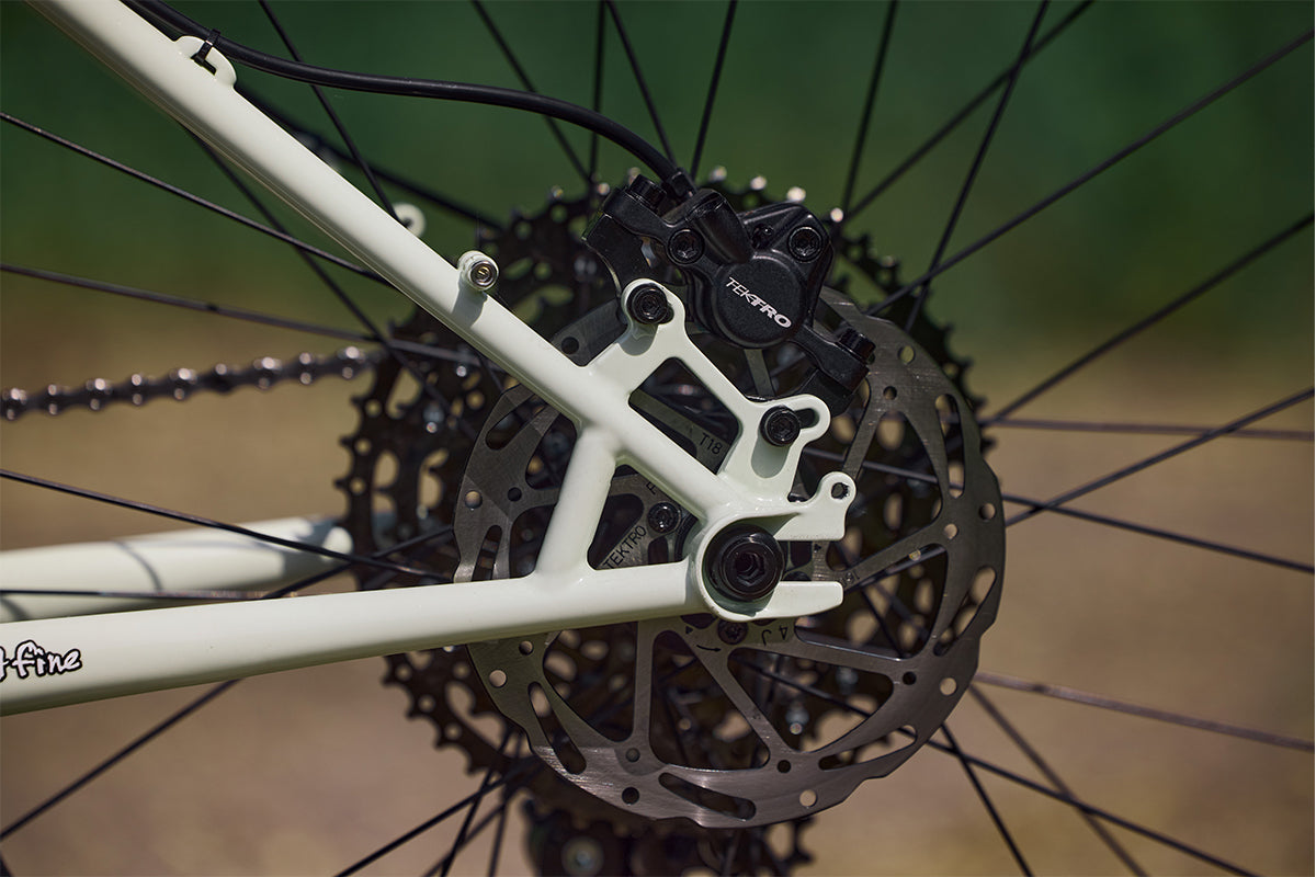 Surly Wednesday bike Key Lime Sneeze color focus on rear disc caliper dropout and rotor